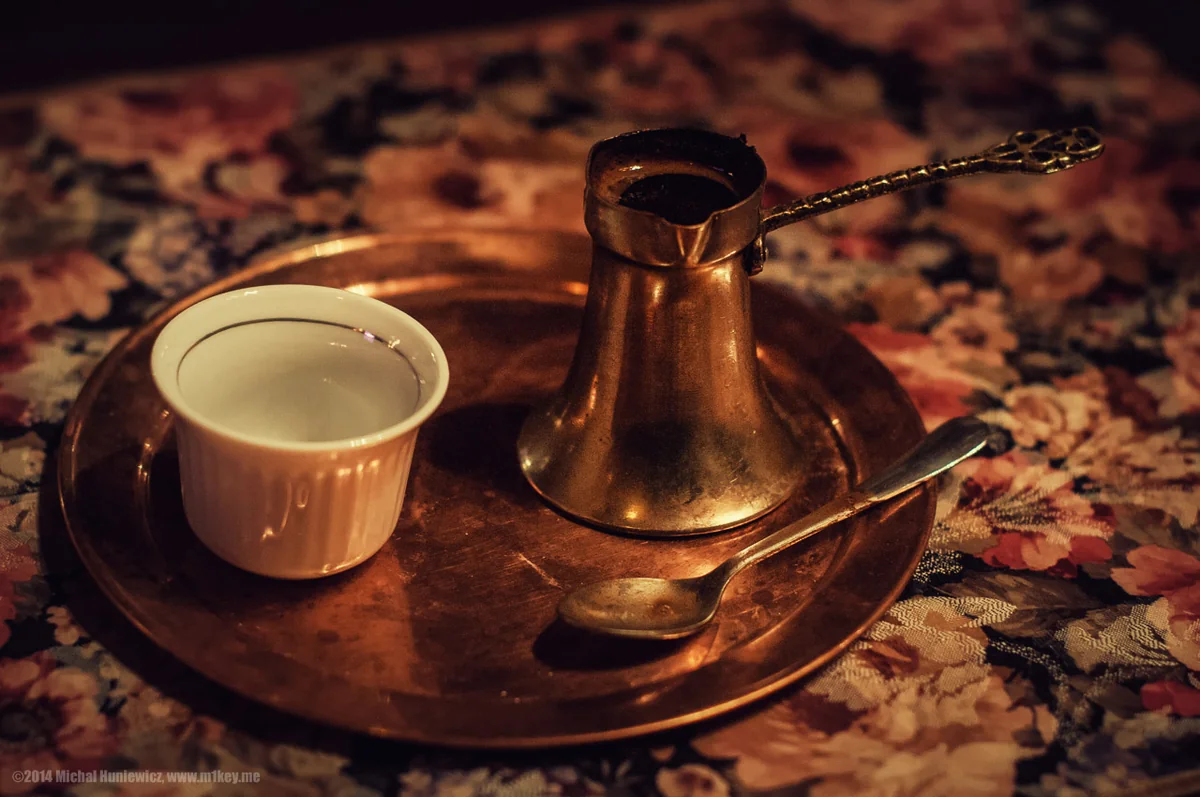 Bosnian coffee in a copper džezva on a tray beside a small white fildžan cup