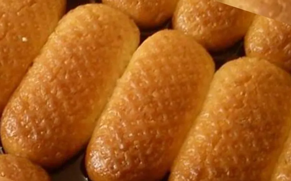 Golden oval Bosnian hurmašice with a grater pattern, soaked in sugar syrup